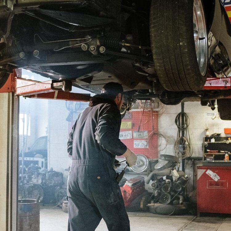 Technician working under a car on the lift